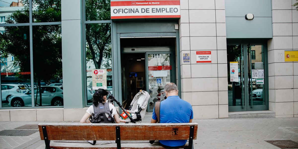 Archivo - Dos personas esperan fuera de una oficina de empleo de Madrid 