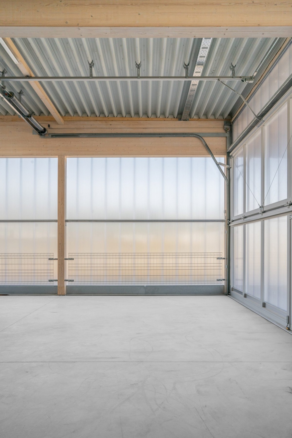 La estructura del almacén está envuelta en paneles de policarbonato translúcido con ventanas practicables, permitiendo la entrada de abundante luz natural.
