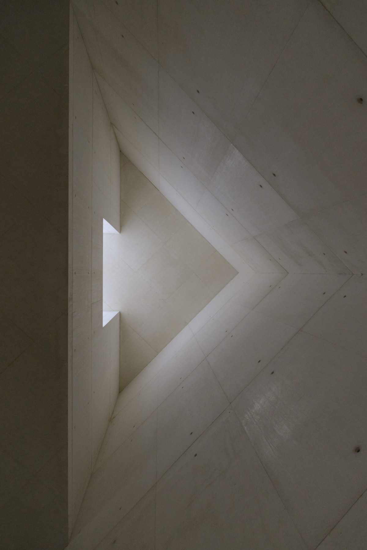 Las aberturas en la torre y el tejado permiten la entrada de luz natural, creando un juego de luces y sombras que enriquece la experiencia espacial y espiritual de los visitantes.