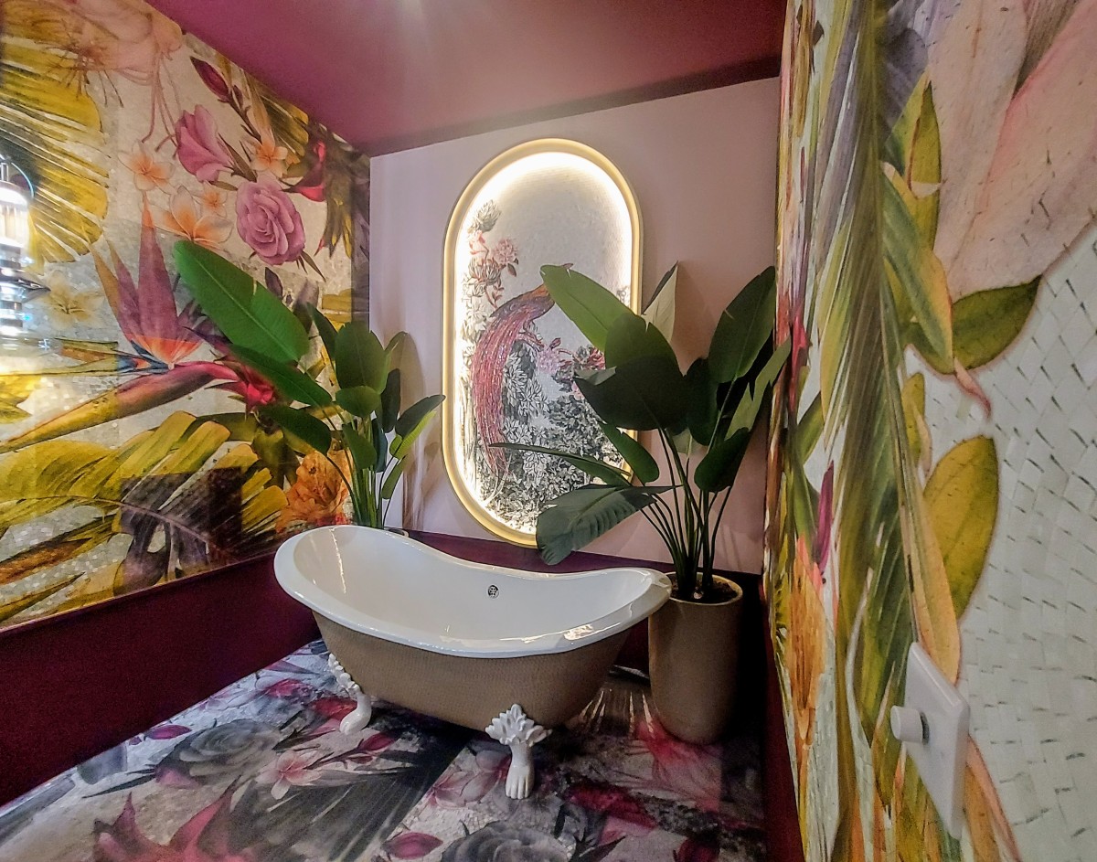 Baño decorado con plantas, motivos botánicos y colores vibrantes.