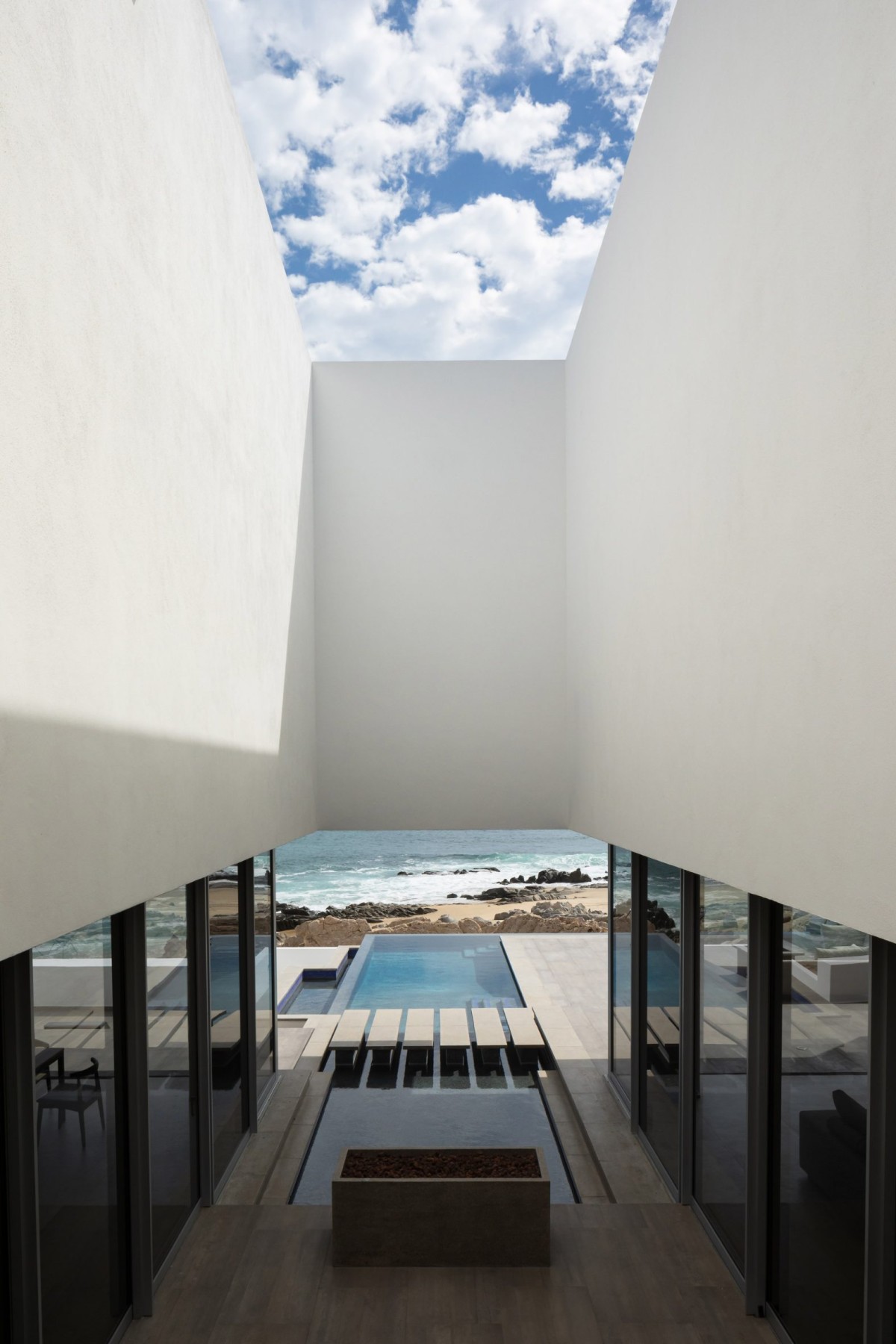 La piscina infinita, ubicada en el extremo opuesto, se convierte en un punto focal y en una extensión natural del horizonte que conecta con el océano.