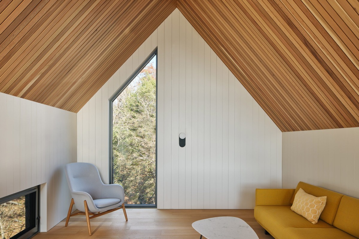 Los suelos de roble se combinan con paredes blancas y listones de cedro rojo que se elevan hasta el techo abovedado.