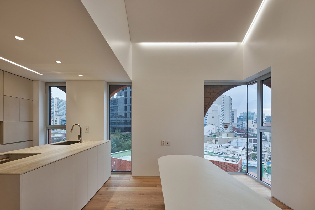 Los espacios interiores mantienen una estética minimalista con paredes blancas, suelos de madera y luminarias ocultas.
