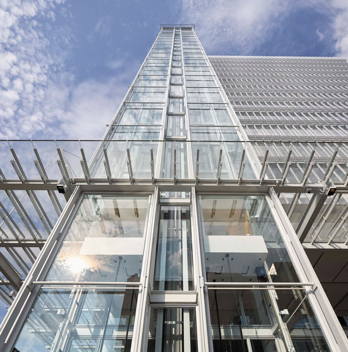 Las fachadas están revestidas de vidrio con montantes estrechamente espaciados que ocultan el cristal desde ciertos ángulos, lo que reduce la escala visual del edificio.