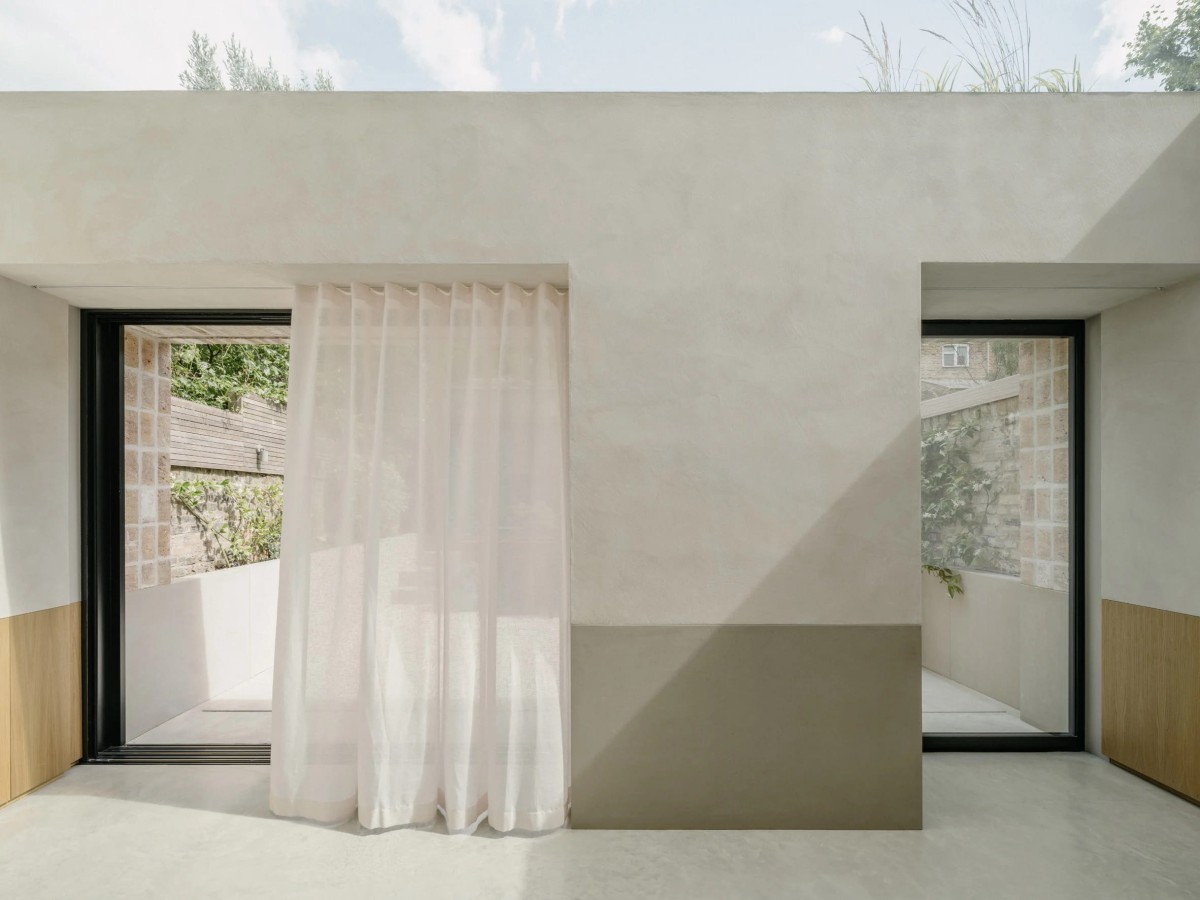 La fachada trasera parece un elemento arquitectónico independiente, en cuyos huecos sirven se ocultan las puertas correderas y los rieles de las cortinas.