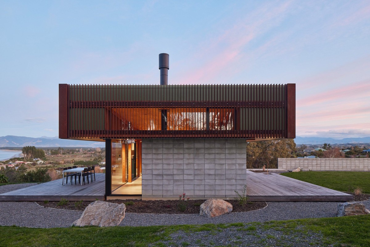 La casa se extiende sobre un zócalo de hormigón visible y sus muros de bloques de hormigón visto recorren las fachadas.