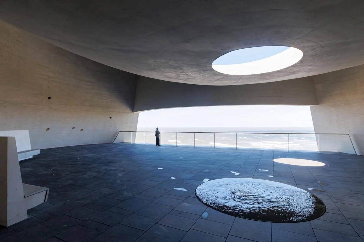 El Espacio Fenómeno cuenta con una apertura circular que permite que la lluvia caiga en un estanque, creando una instalación acuática que simboliza el ciclo de la naturaleza.