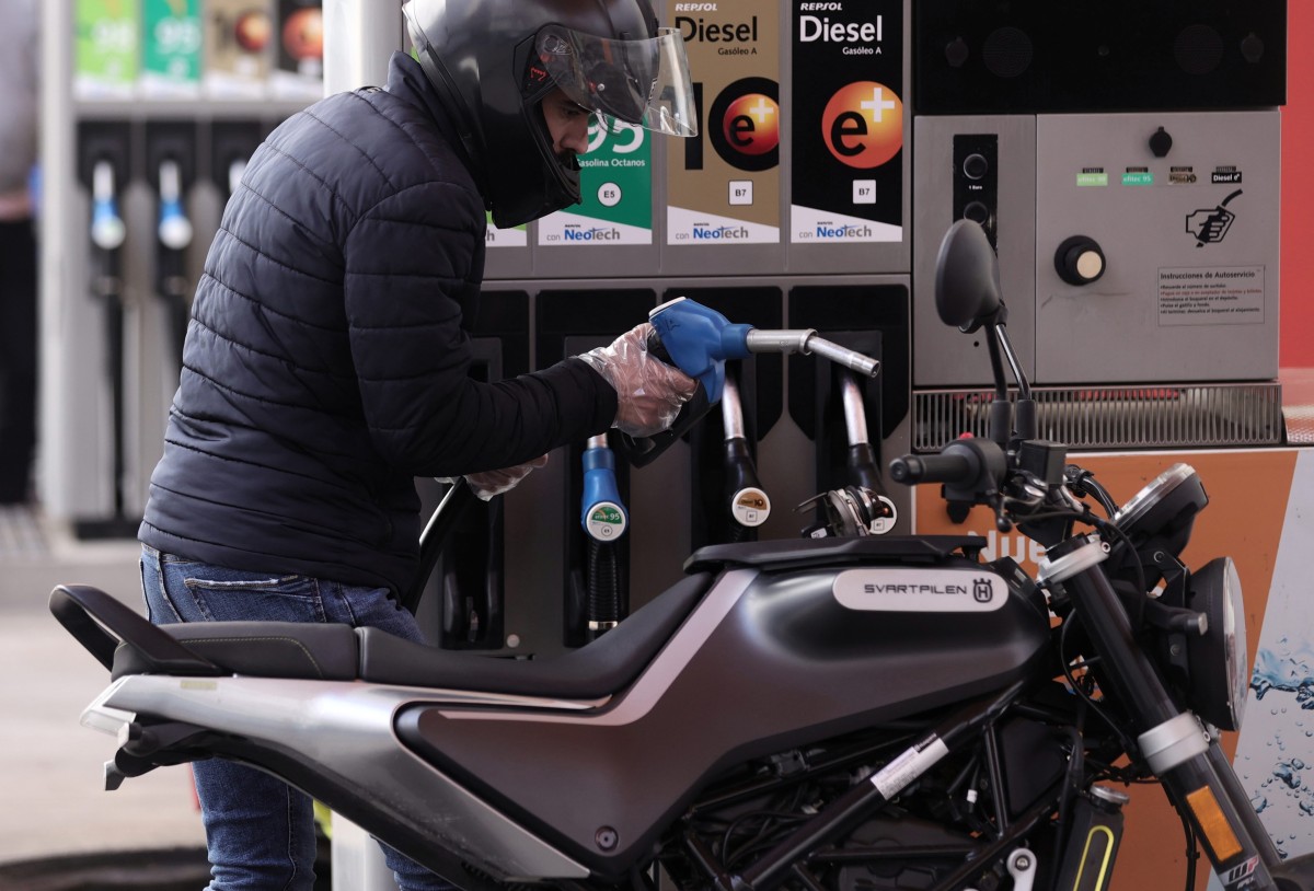 El IPC sube cuatro décimas en diciembre y cierra el año en el 2,8% por el encarecimiento de las gasolinas Archivo - Un hombre llena el depósito de su moto