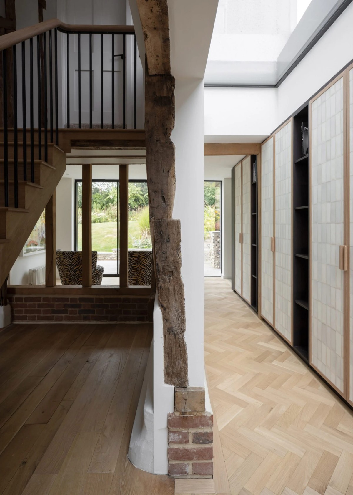 La ampliación moderna crea un contraste visual con la estructura más rústica del granero y la casa principal.