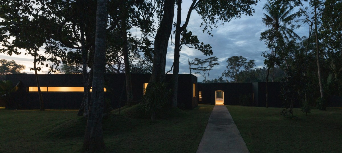 El camino de entrada atraviesa una zona de césped y guía a los visitantes hacia la zona principal de la casa.