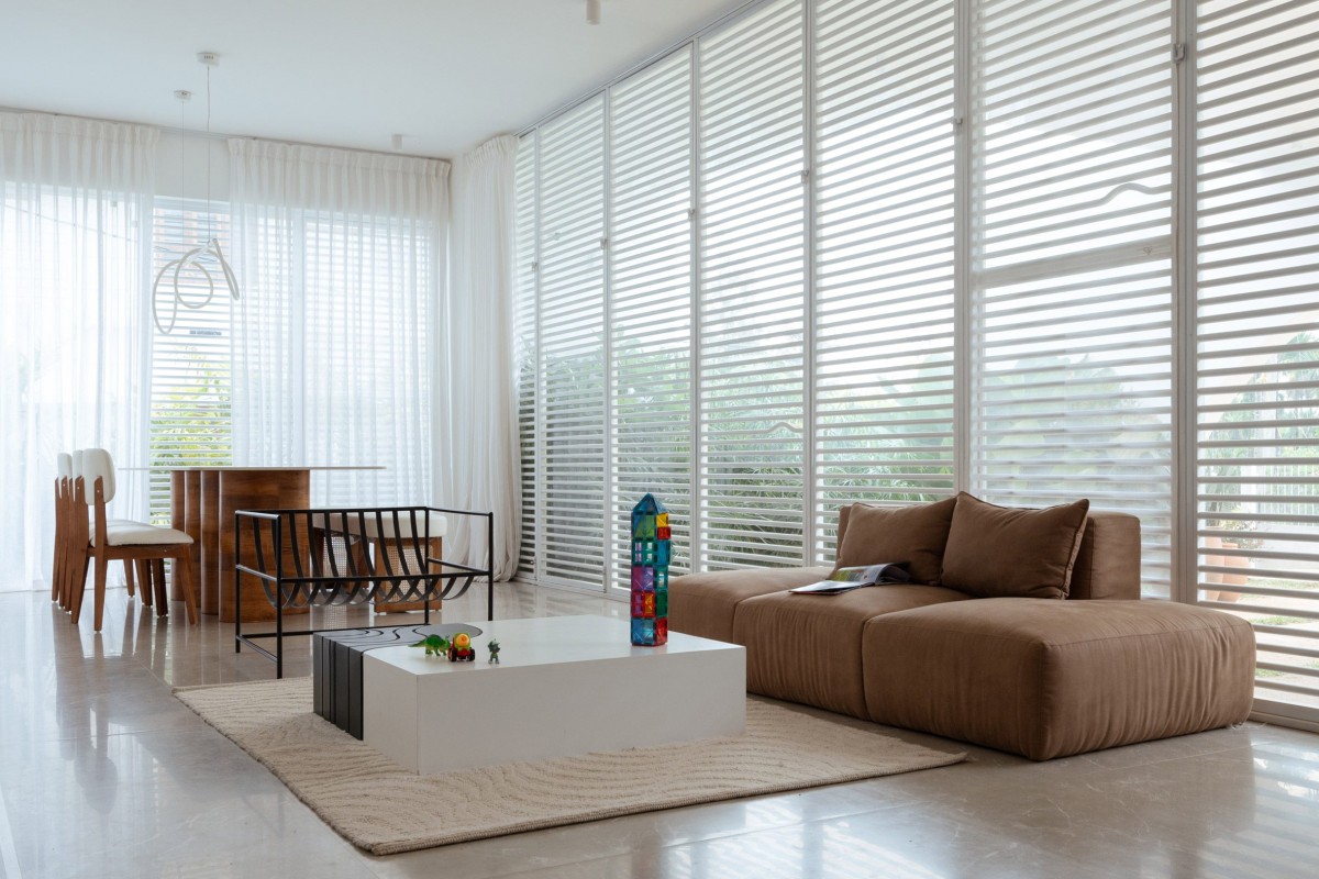 Las ventanas cuentan con cortinas translúcidas y finas lamas o rejillas metálicas que unen los espacios y mejoran la sensación de luz y aire.