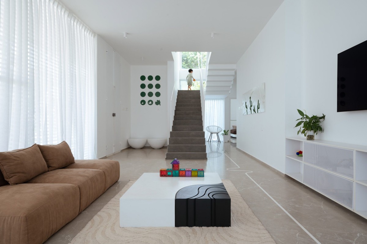 La escalera central da acceso al dormitorio principal, que cuenta con un baño en suite y una terraza-jardín privada.