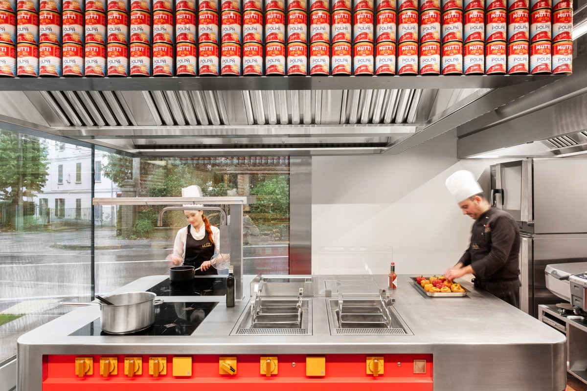 Las latas Mutti recicladas crean un elemento de diseño en una gran ventana que da a la calle y en la propia cocina.