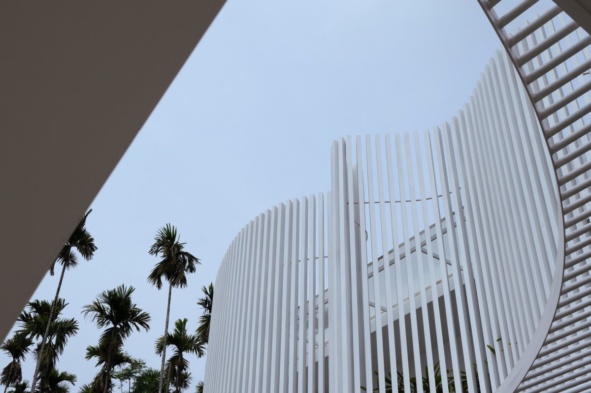 La terraza está protegida de la vista de la calle por barras metálicas curvas que replican la forma del muro exterior.