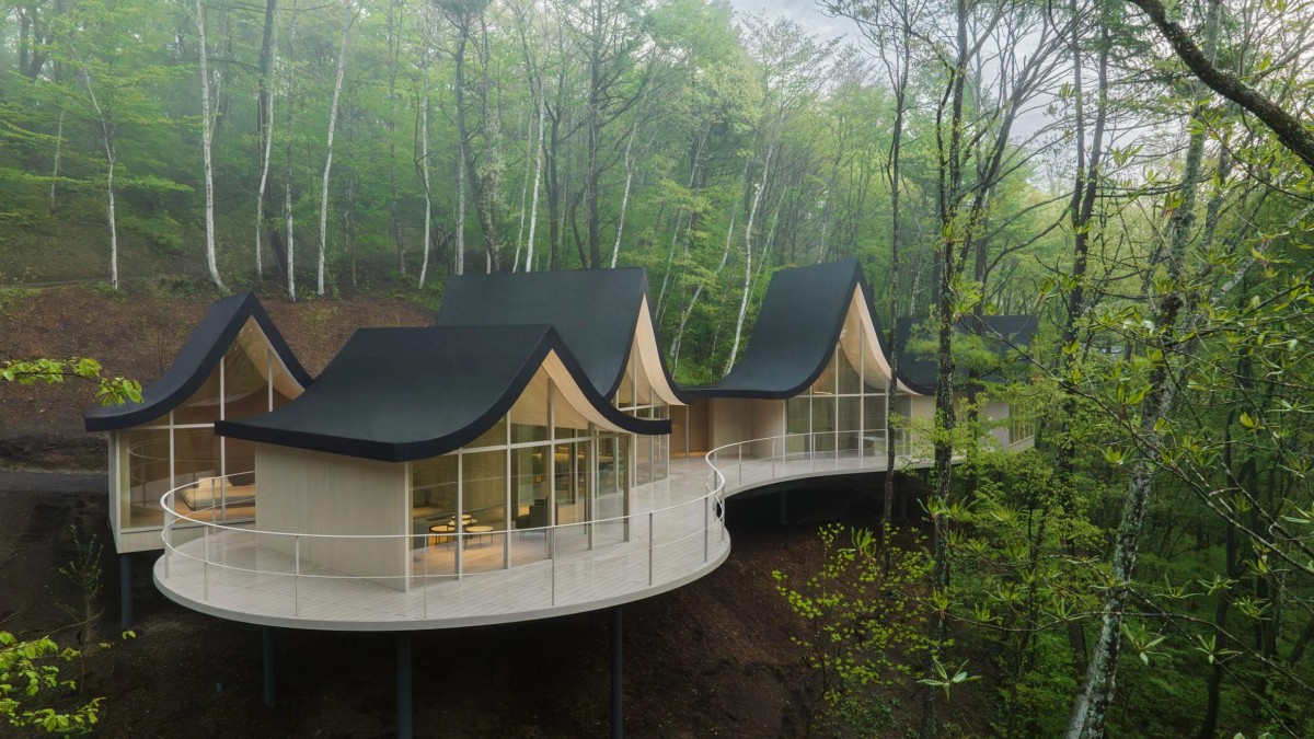 El proyecto destaca por entrelazar seis casitas de madera mediante un techo sinuoso que simboliza a "una familia cogida de la mano".