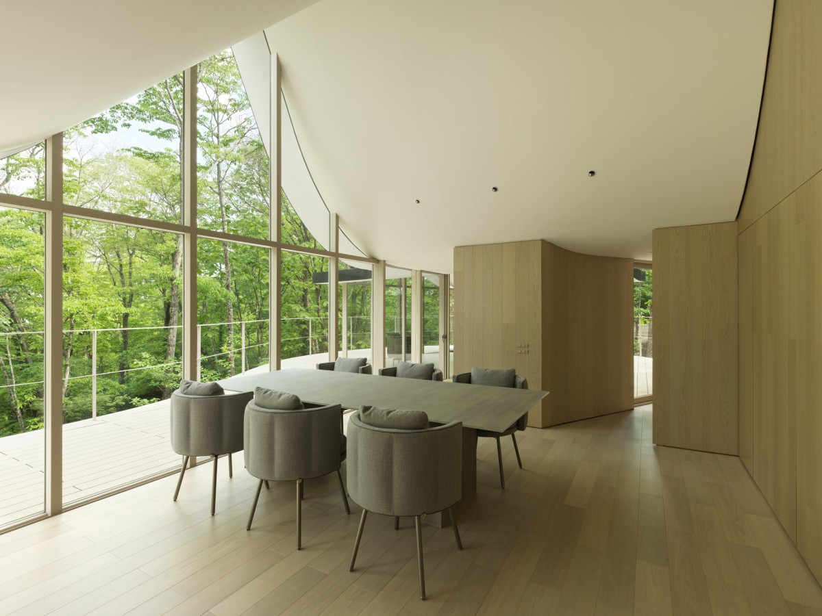 El diseño emplea paneles de madera en paredes y suelos que crean un ambiente minimalista, cálido y acogedor.