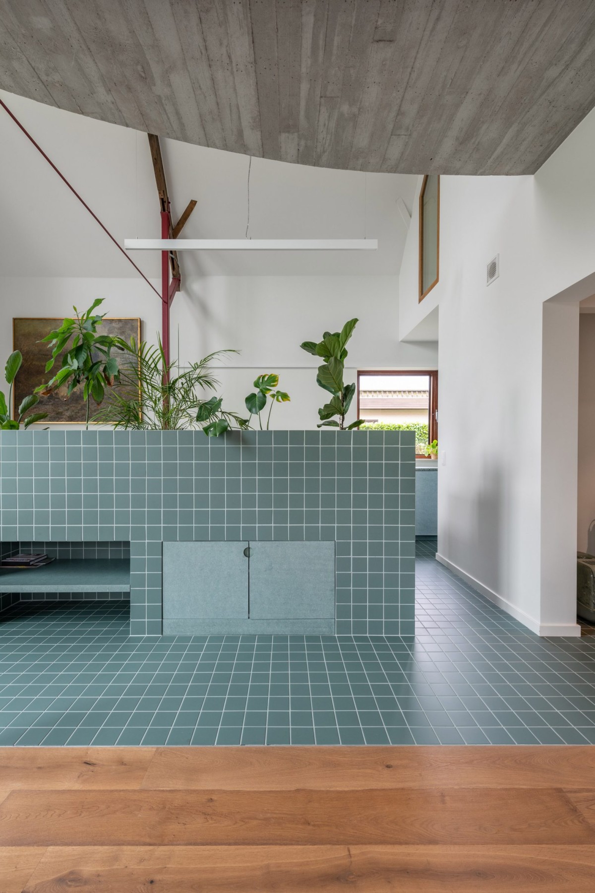 Para marcar la transición entre la cocina y el comedor se incorporó una jardinera tropical de azulejos azul claro, aportando un toque de frescura y vitalidad al ambiente.