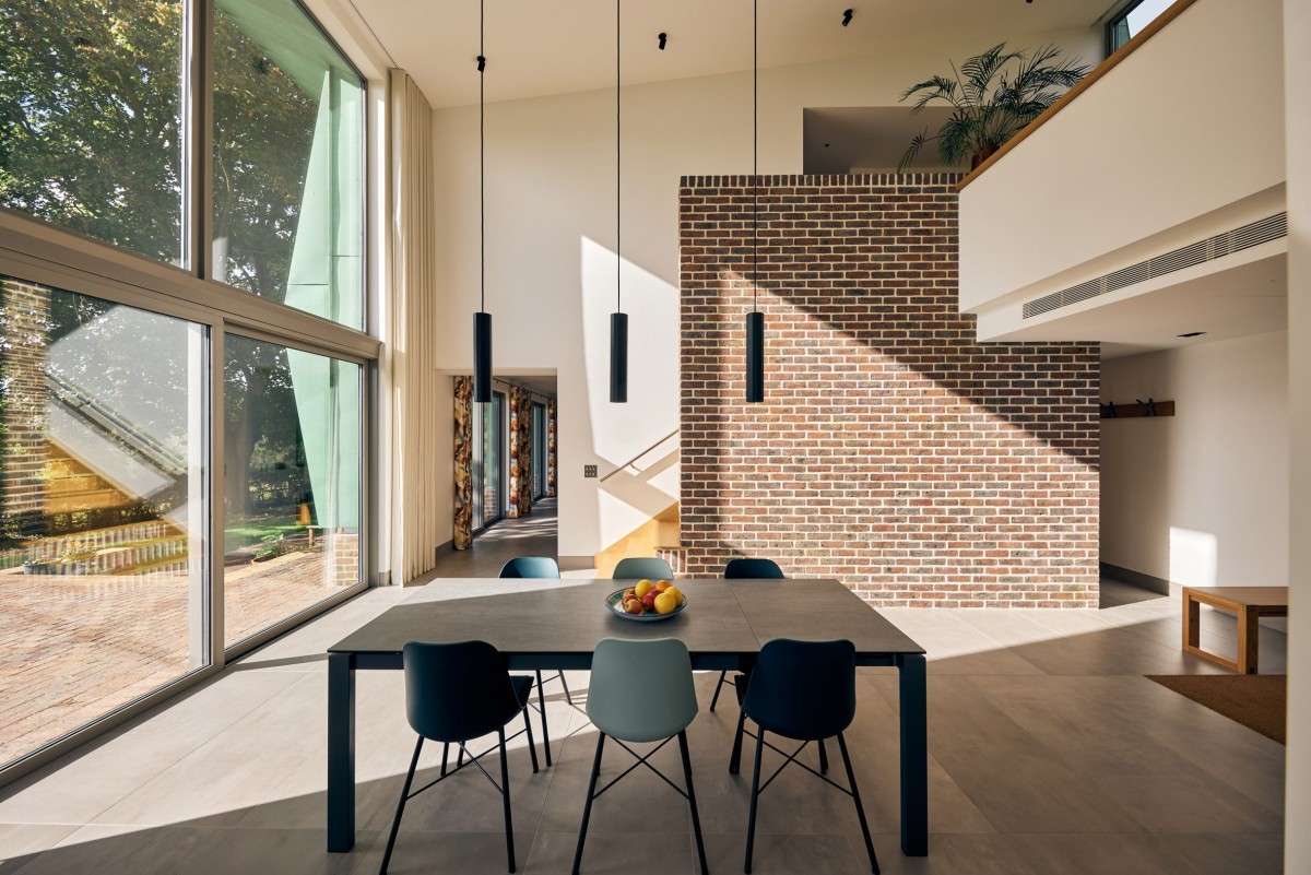 El corazón de la casa es un espacio a doble altura conectando visualmente el salón y la cocina de planta abierta con un altillo diseñado como espacio de trabajo.