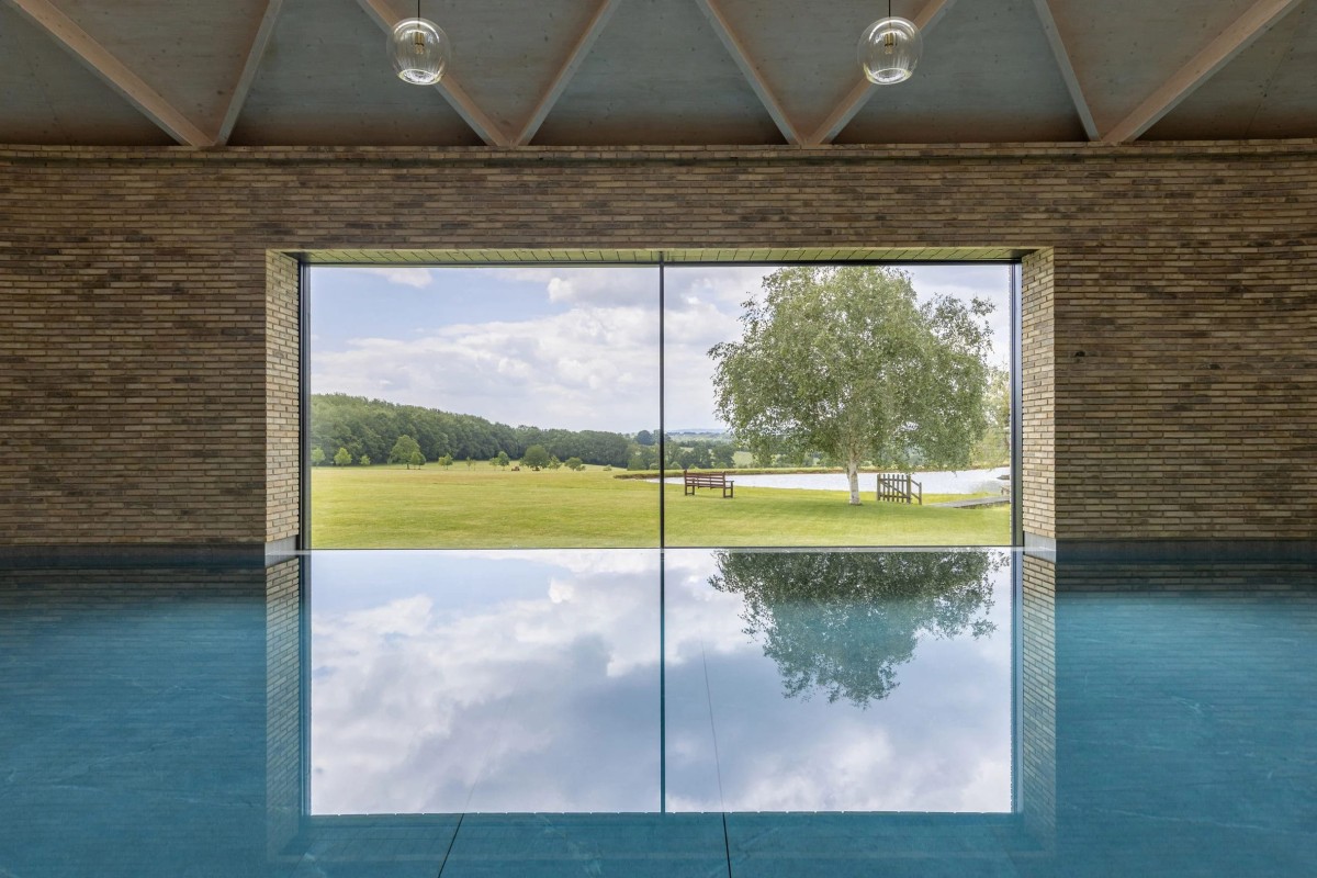 La gran ventana panorámica ofrece vistas espectaculares del paisaje a través de una piscina infinita.