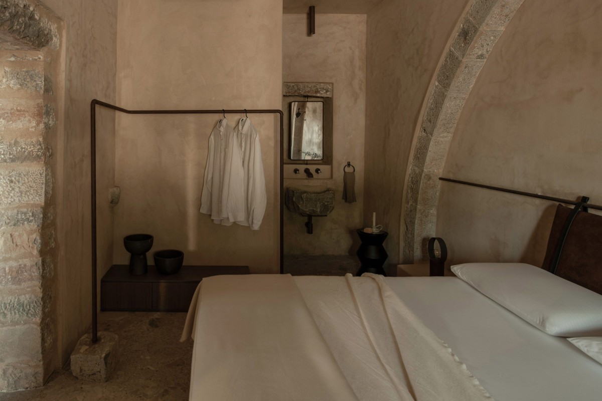 La cama se flanquea por un aseo y una bañera independiente en cada lado, reforzando la sensación de amplitud dentro de un espacio compacto.