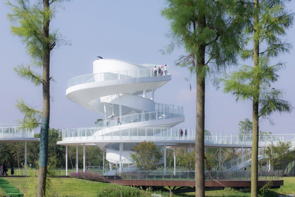 La torre de observación de doble hélice se eleva desde la planta baja y, atravesando el tejado metálico, ofrece unas vistas panorámicas de la lejana montaña Longmen.