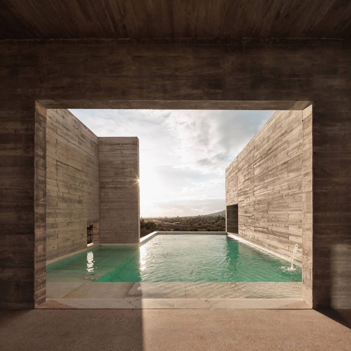 La piscina está flanqueada por unos altos muros que enmarcan el paisaje como si de un cuadro se tratara.