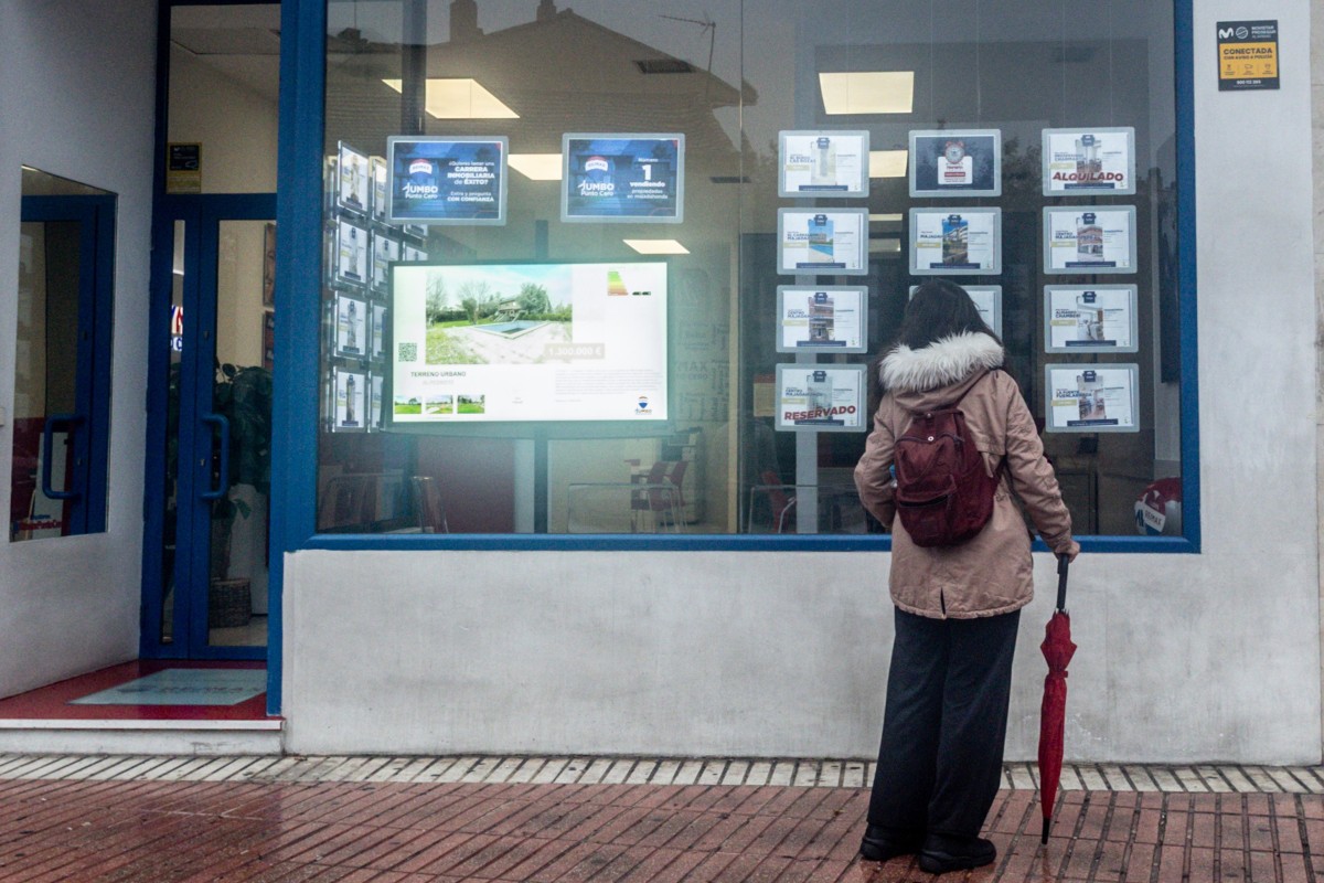 Las compraventas de vivienda suben un 5,3% hasta marzo, con el precio en nuevos máximos, según registradores Archivo - Una mujer observa las ofertas de una inmobiliaria