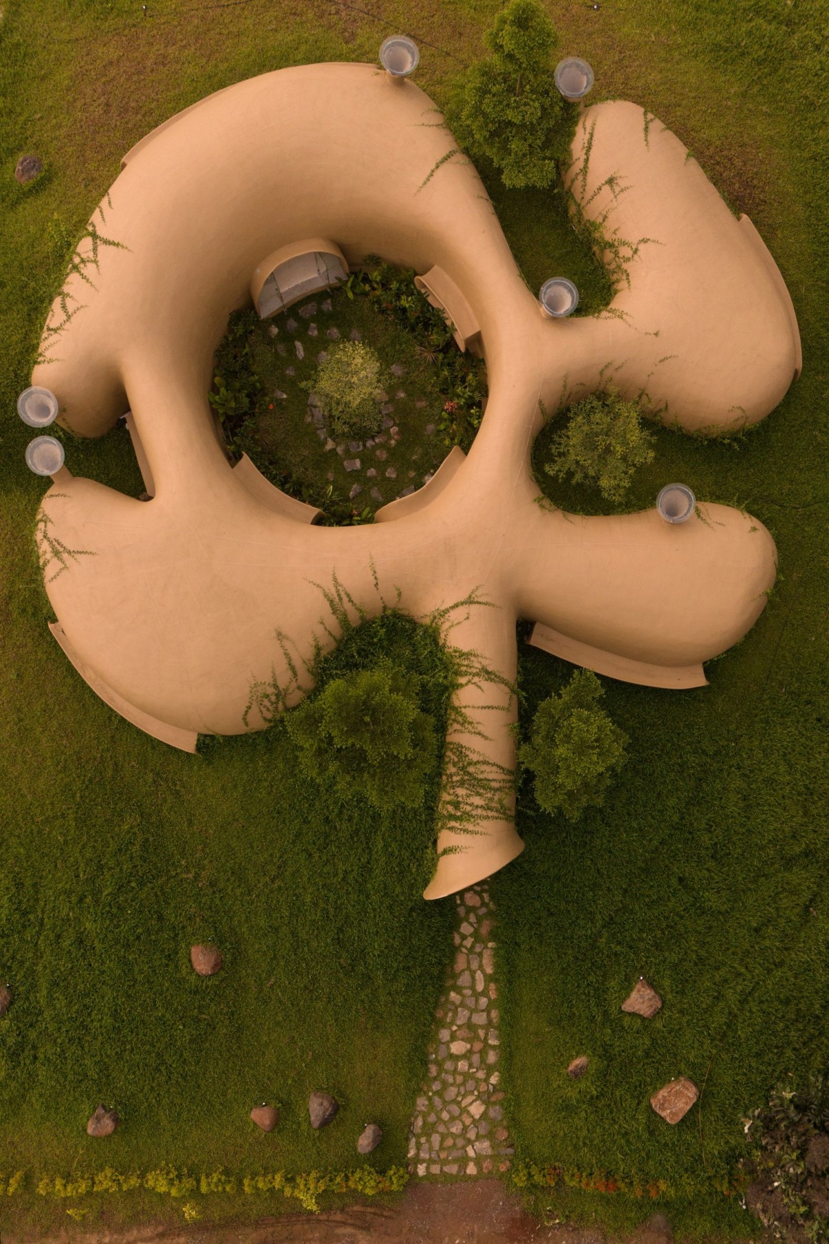 Un patio central arbolado distribuye los distintos espacios interiores que giran a su alrededor.