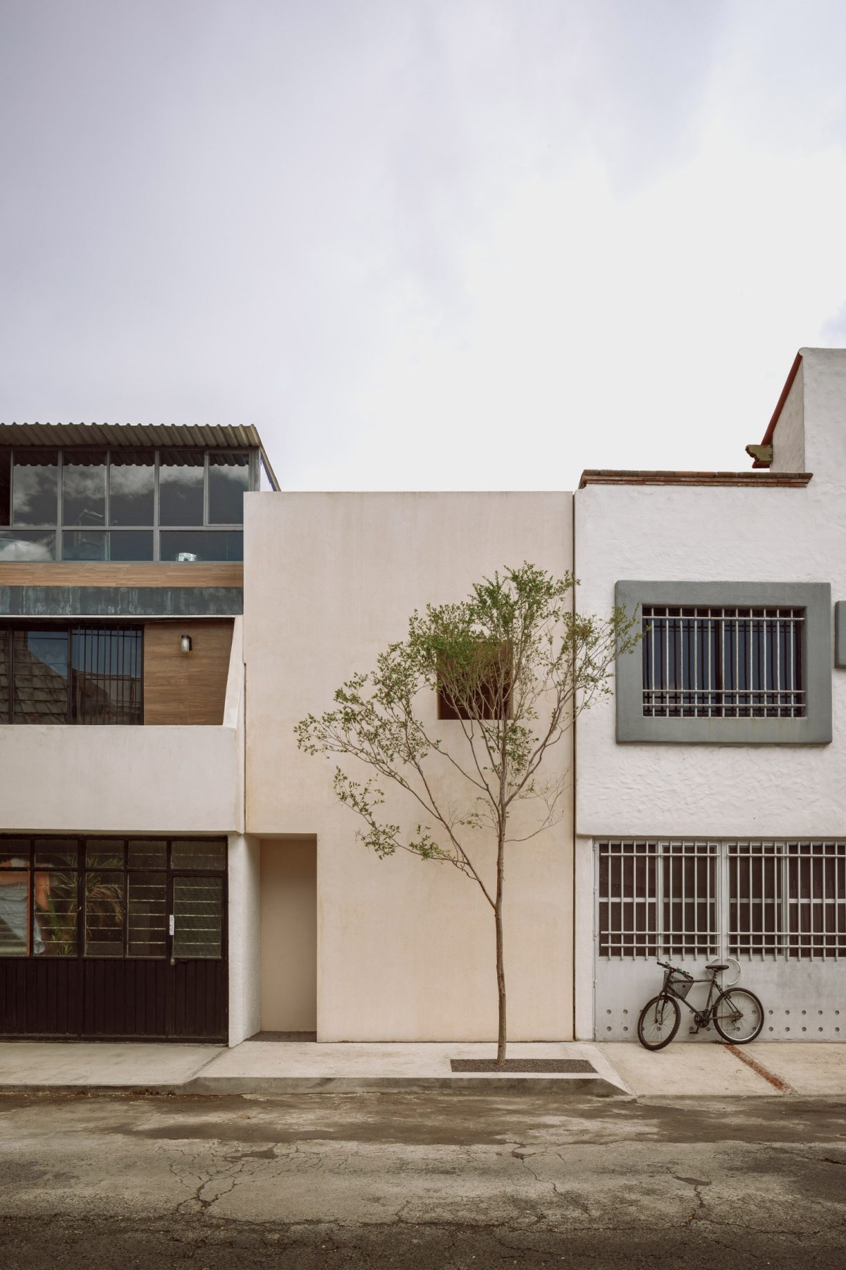 La fachada es plana, revestida con chukum color aren, con una única ventana en sombra y una discreta entrada.