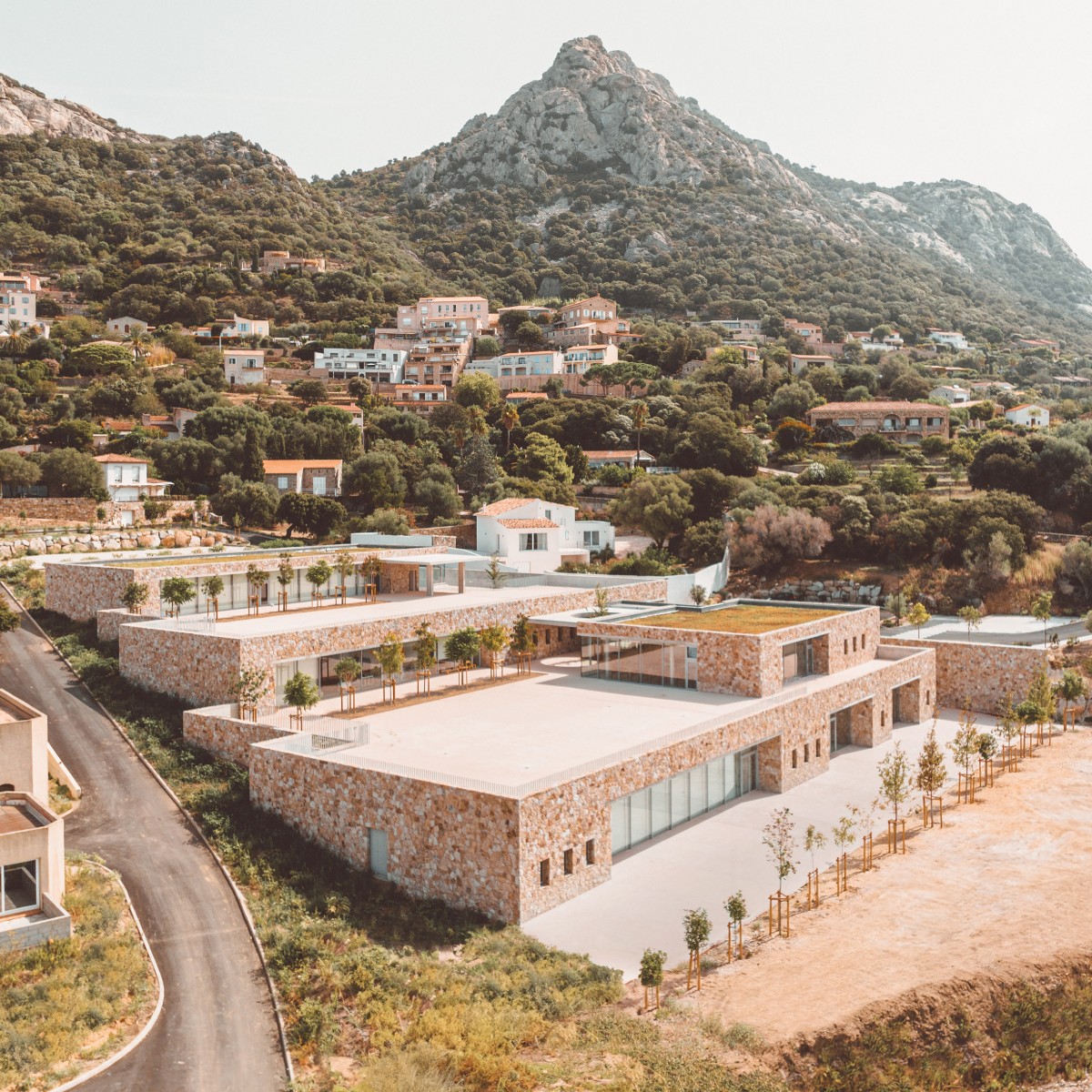Los módulos están revestidos con bloques de granito rugoso que parecen pertenecer al paisaje corso desde siempre.