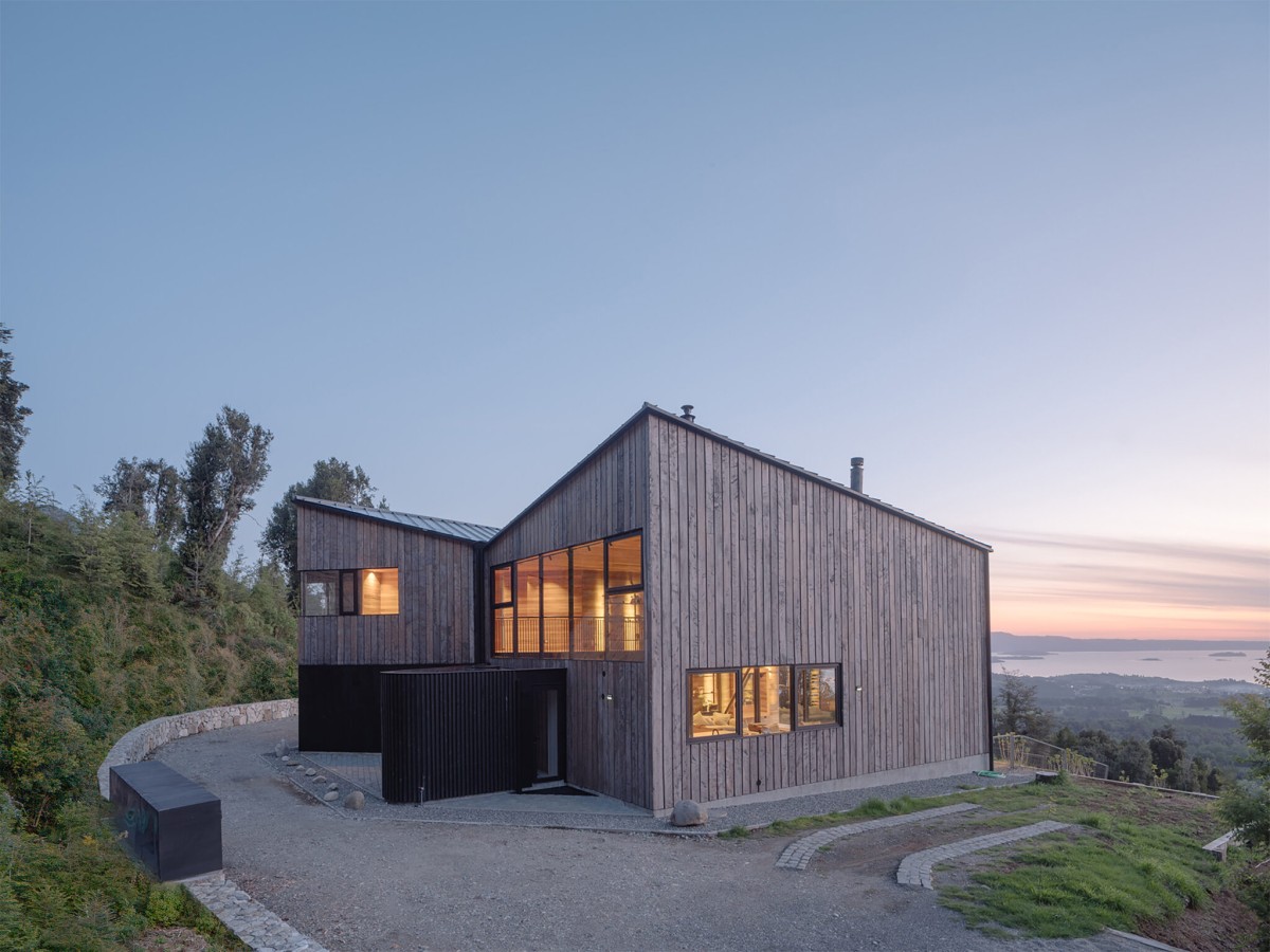 Para el revestimiento exterior se empleó el roble hualle, una madera autóctona del sur de Chile, que conecta visualmente la vivienda con el paisaje boscoso que la rodea.