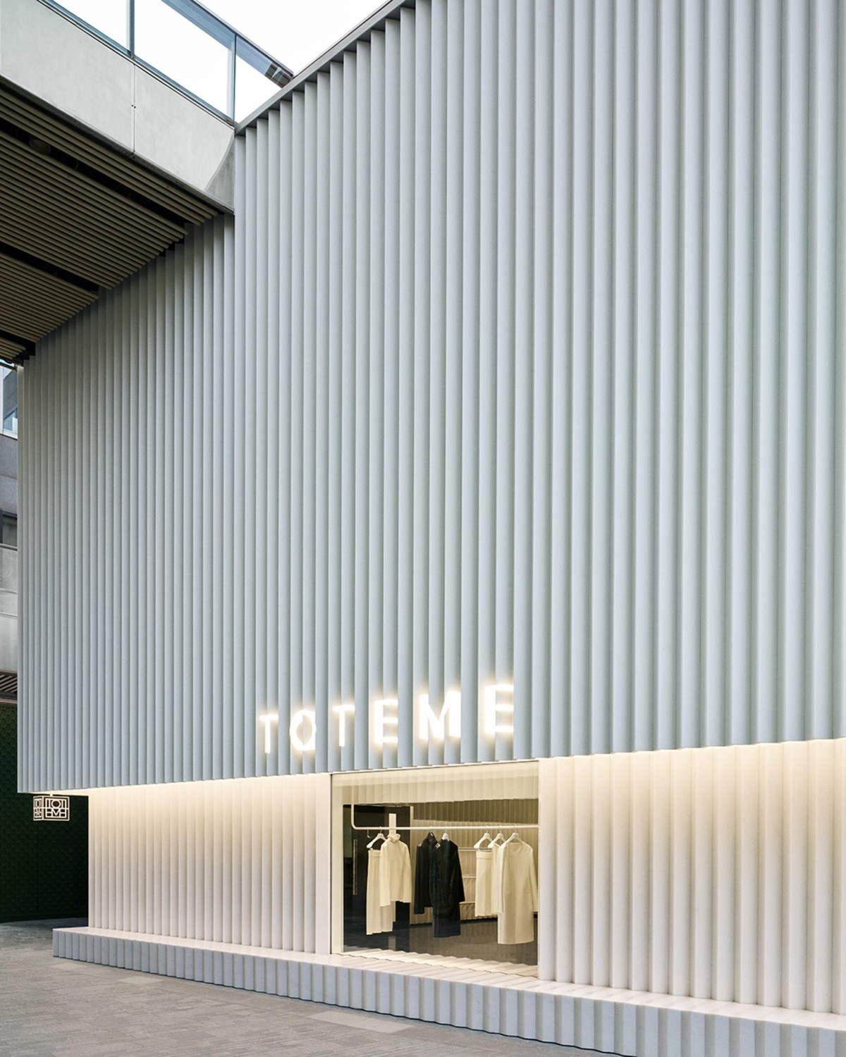 La fachada presenta un diseño de bloques de piedra blanca y metal dispuestos en forma de pliegues.