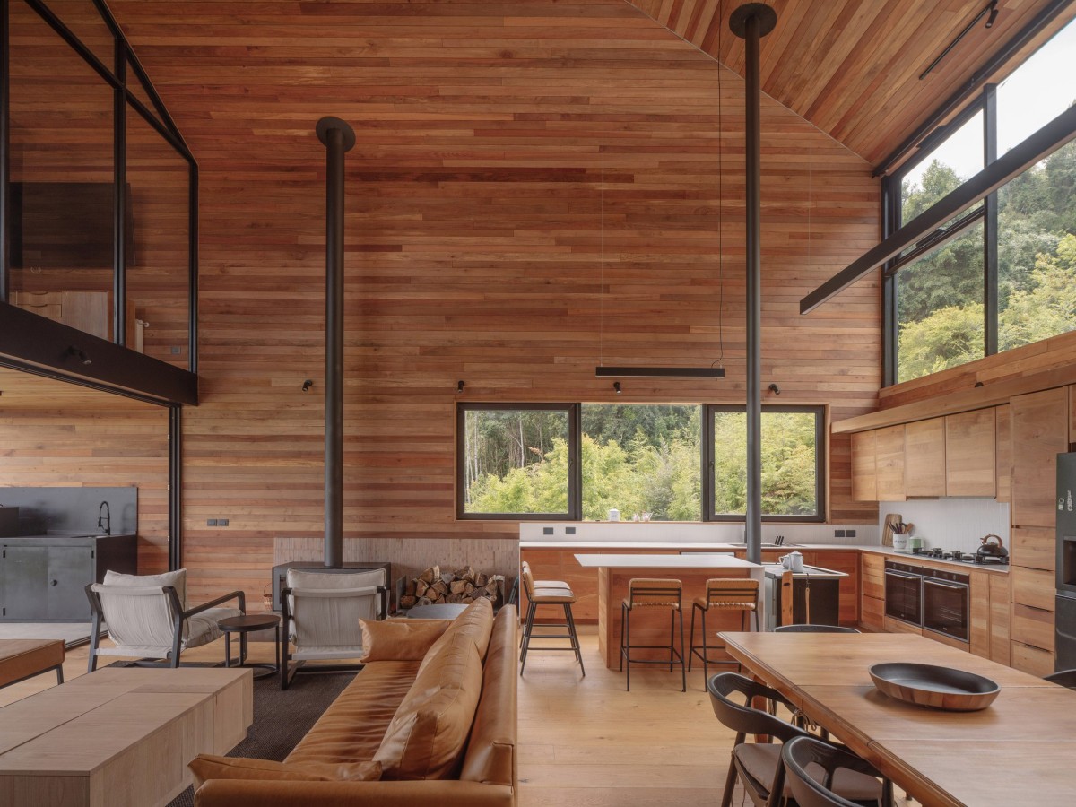 En uno de los volúmenes se acoge la zona social, ubicando la cocina de doble altura, el comedor, el salón y una terraza cubierta.