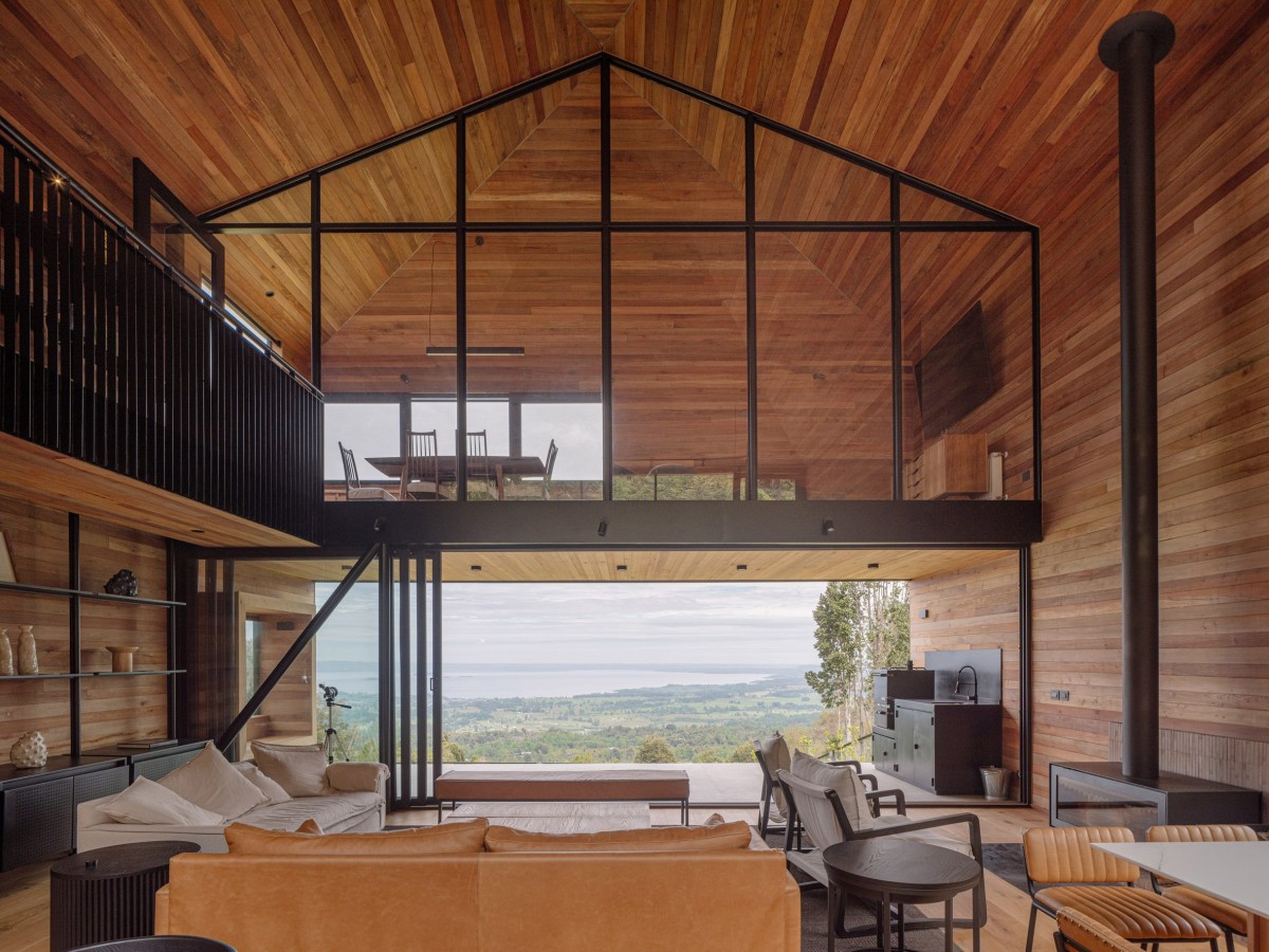 Hacia el lago, la casa cuenta con un entrepiso sobre la cocina, con una pared acristalada que refuerza la sensación de apertura.