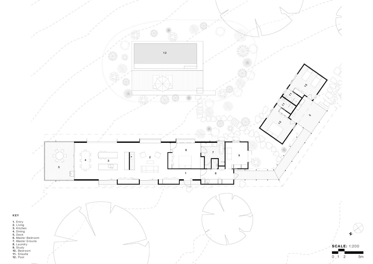 El diseño responde a una configuración en forma de L, formada por dos alas diferenciadas conectadas por una pasarela exterior cubierta.