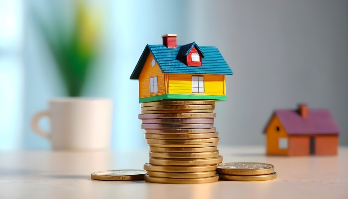 Cómo mantener la deducción por inversión en vivienda habitual al cambiar de hipoteca Casa de juguete con monedas simbolizando ahorro en hipoteca y deducciones fiscales
