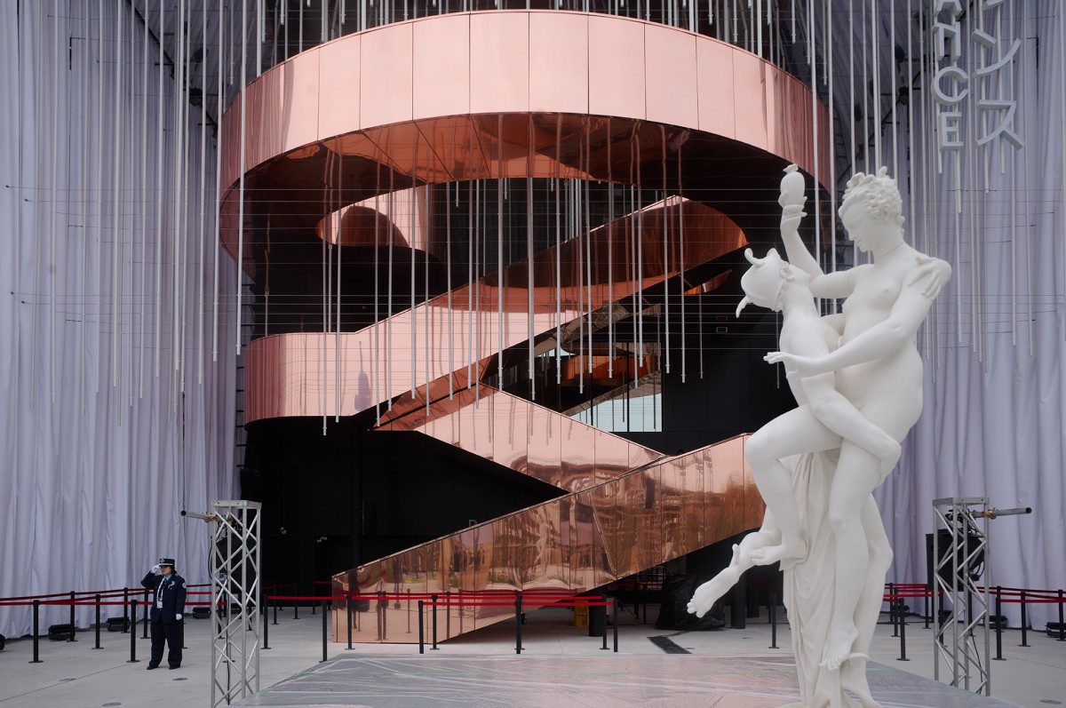 La gran escalera central, revestida en cobre y visible desde el exterior, serpentea como si flotara, ofreciendo acceso a una plataforma de observación.