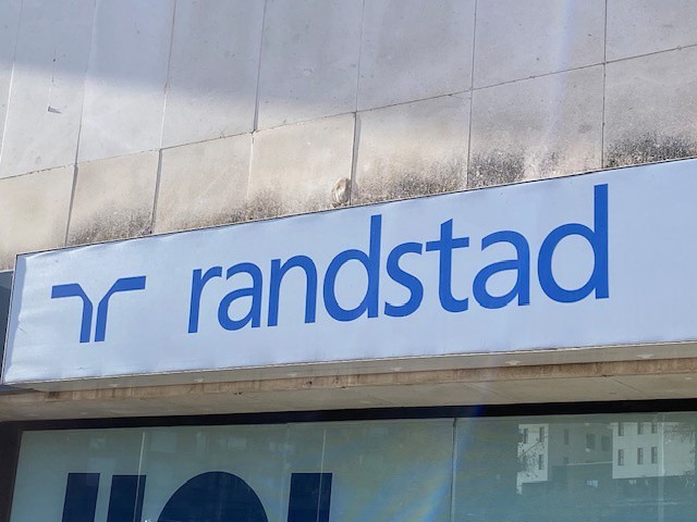 El 46% de los trabajadores afirma que la conciliación es el primer motivo para cambiar de empleo Archivo - Logo de Randstad en una de sus oficinas.