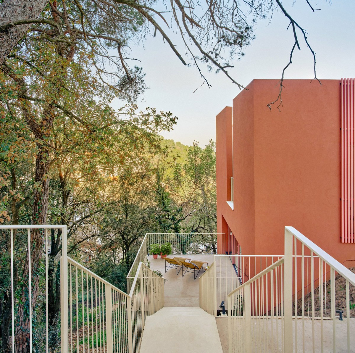 Ubicada cerca de Barcelona, la Casa Magarola ha sido diseñada por el estudio Raúl Sánchez Arquitectos con un revestimiento de color naranja.