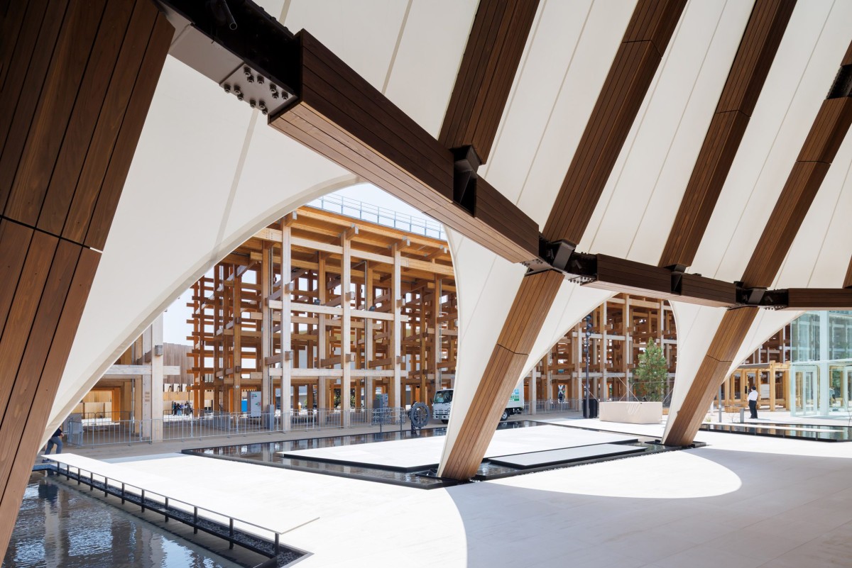 Las aberturas arqueadas de la fachada textil permiten entrever la pasarela que circunda el edificio de madera.