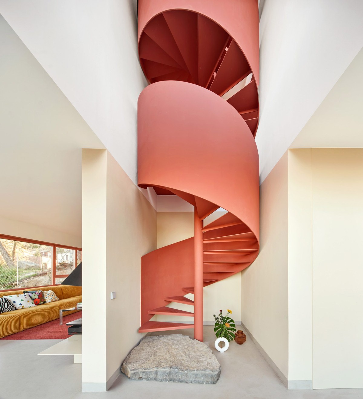 Las plantas se conectan por una escalera de caracol metálica pintada del mismo naranja que las fachadas.