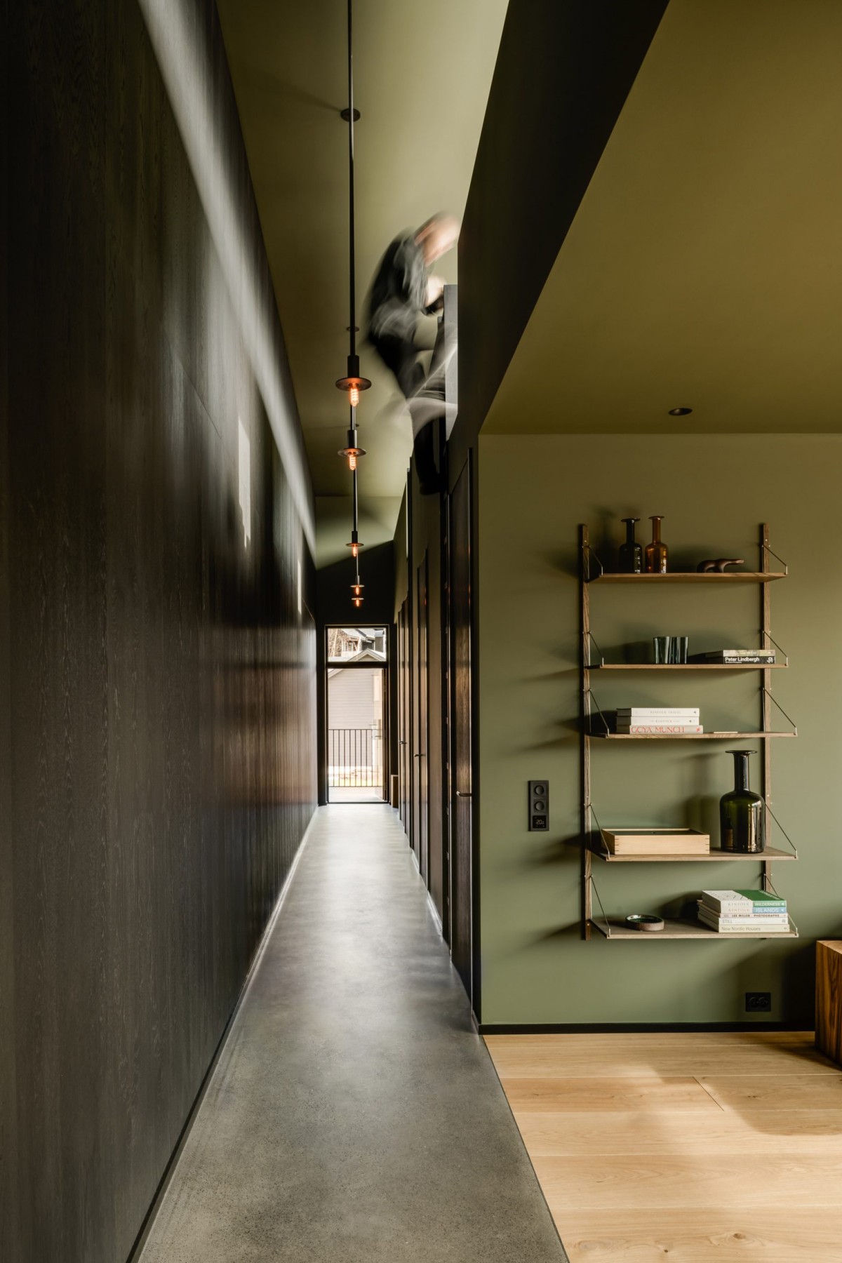 El pasillo actúa como transición hacia el corazón de la casa, donde se concentran la sala de estar, la cocina y los dormitorios.