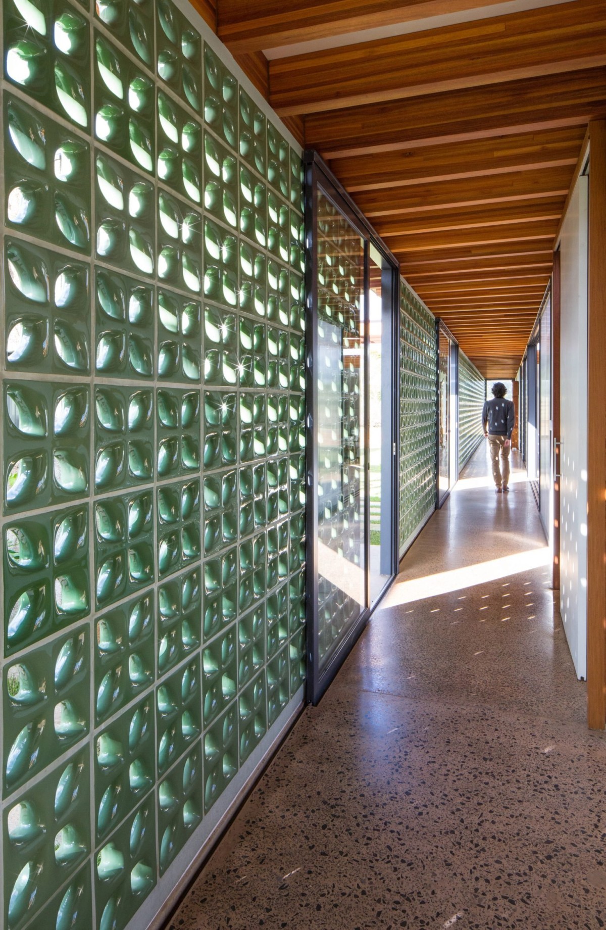 El muro de bloques cerámicos alberga el pasillo de casi 50 metros que se convierte en la columna vertebral del proyecto.