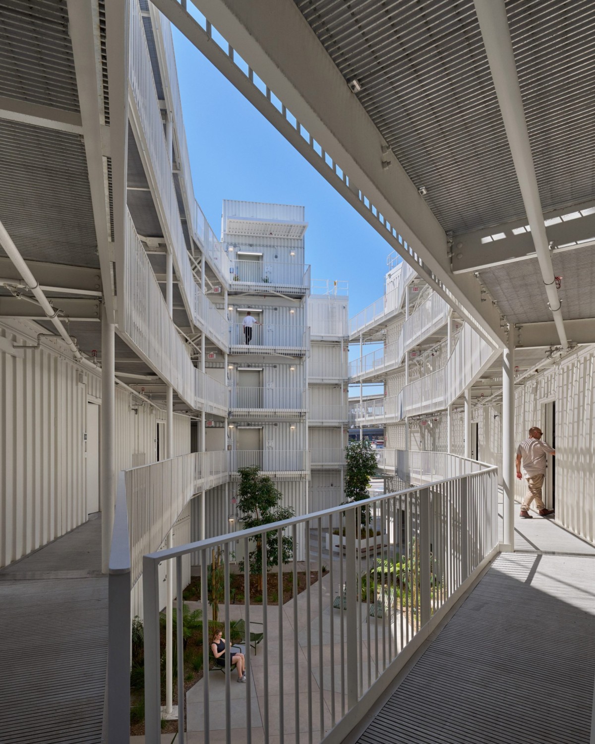 El conjunto se organiza en volúmenes blancos escalonados dispuestos en torno a un patio central. 