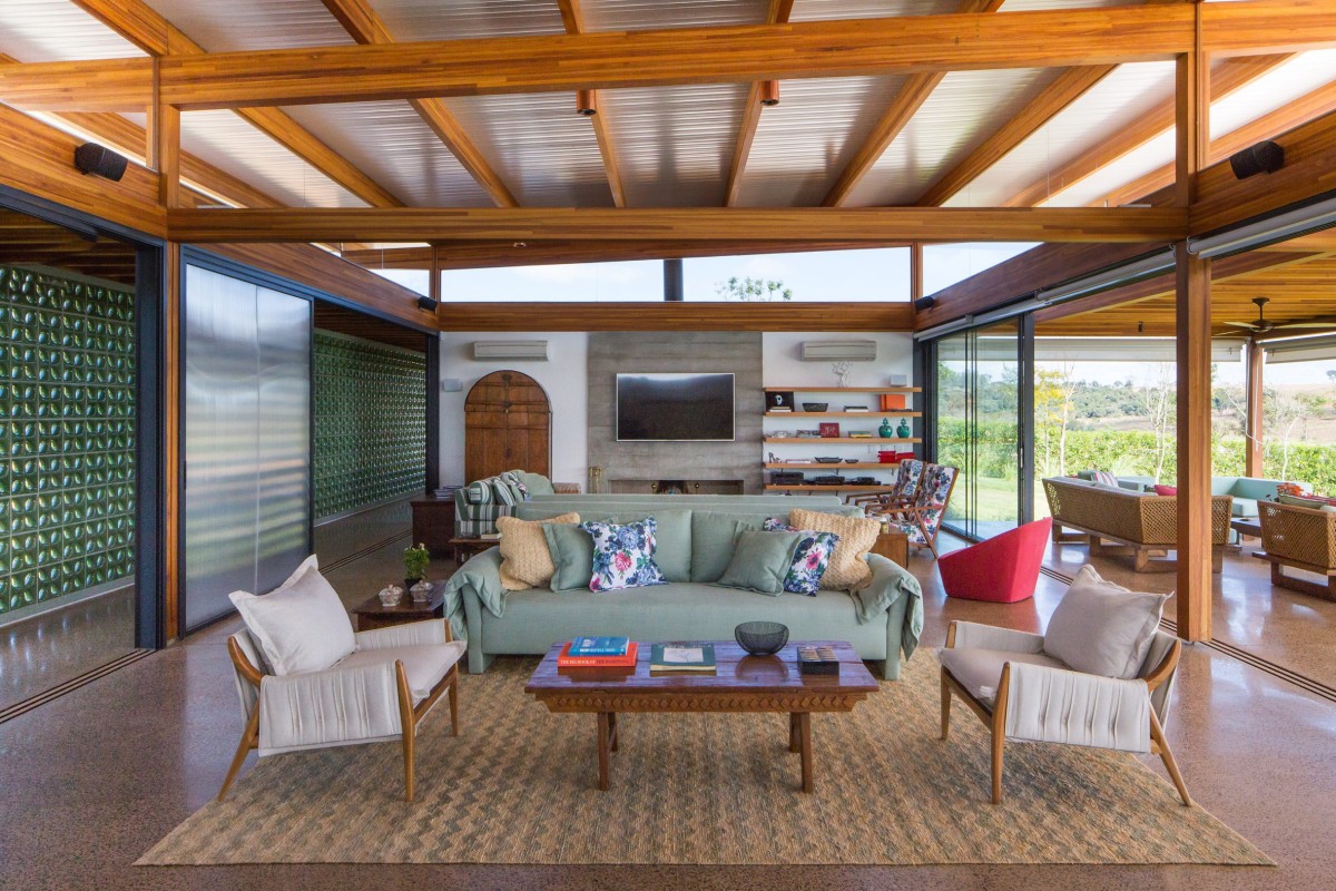 El bloque central diáfano alberga la zona social de la vivienda con salón, cocina y comedor que se abre completamente a una terraza con vistas al embalse.