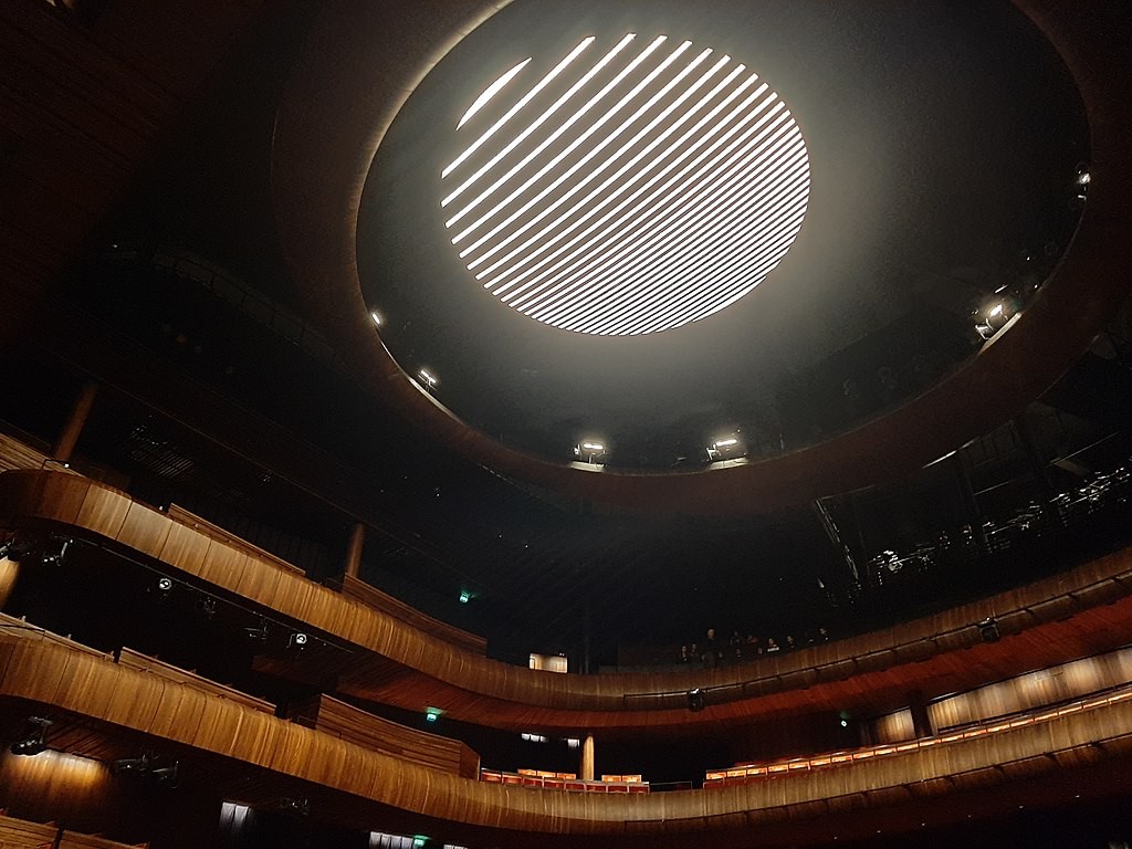 Una araña contemporánea compuesta por 5.800 cristales y 800 luces LED ilumina el techo con destellos.