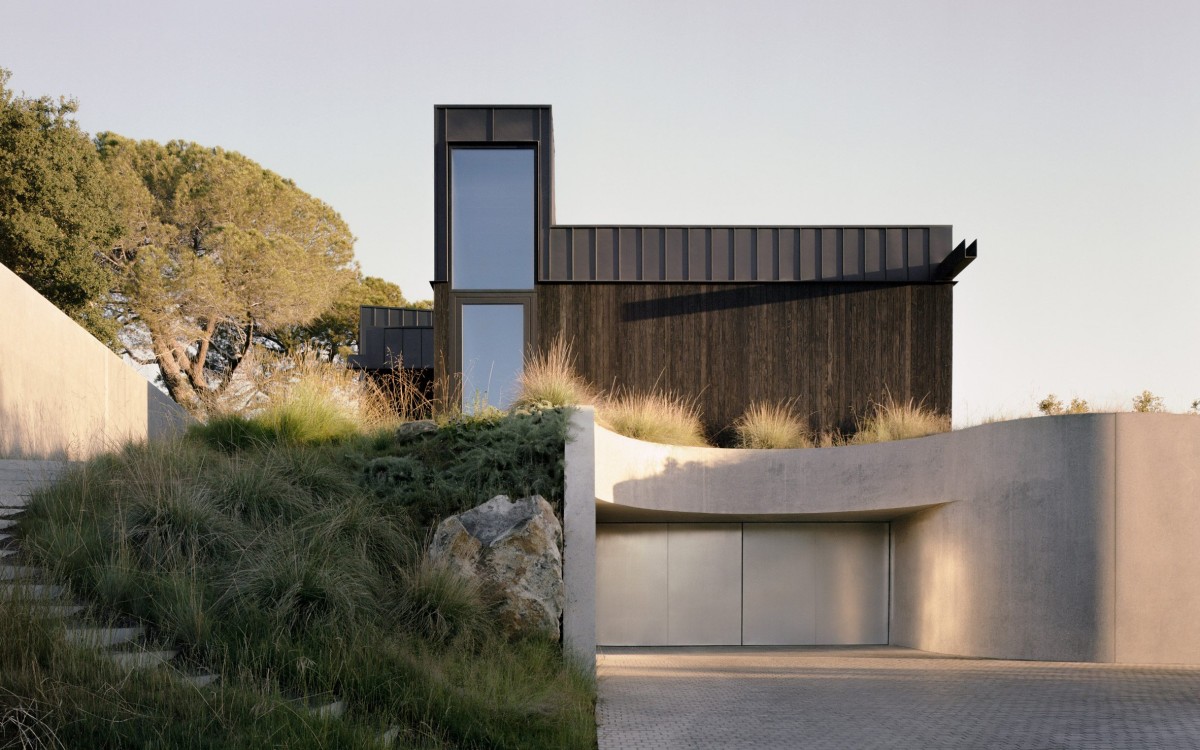 La vivienda se organiza en dos niveles complementarios, pero divergentes entre sí, la superior revestida de madera ennegrecida y metal, y la inferior de hormigón.