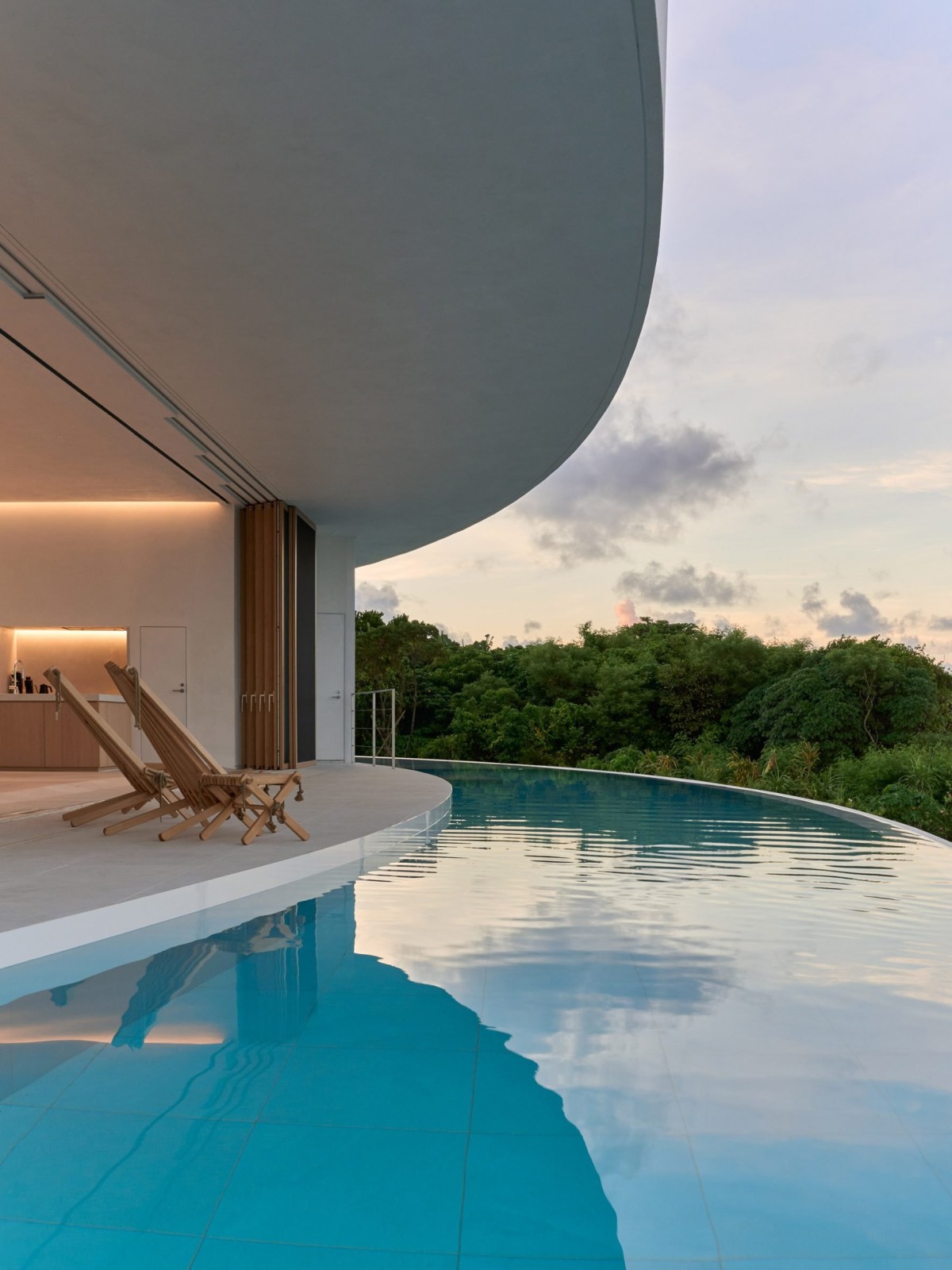 La piscina infinita continúa la curva del edificio.