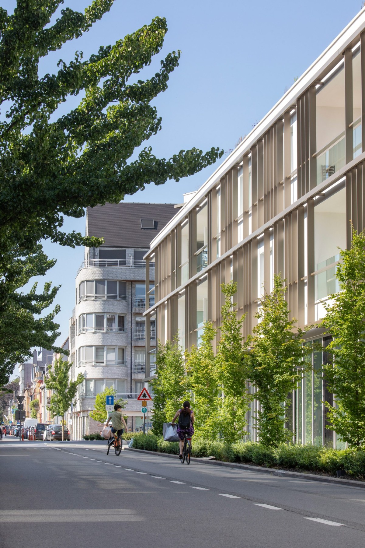 Las fachadas combinan metal y vidrio, y se articulan mediante persianas metálicas angulares que filtran la luz y otorgan dinamismo a la superficie.