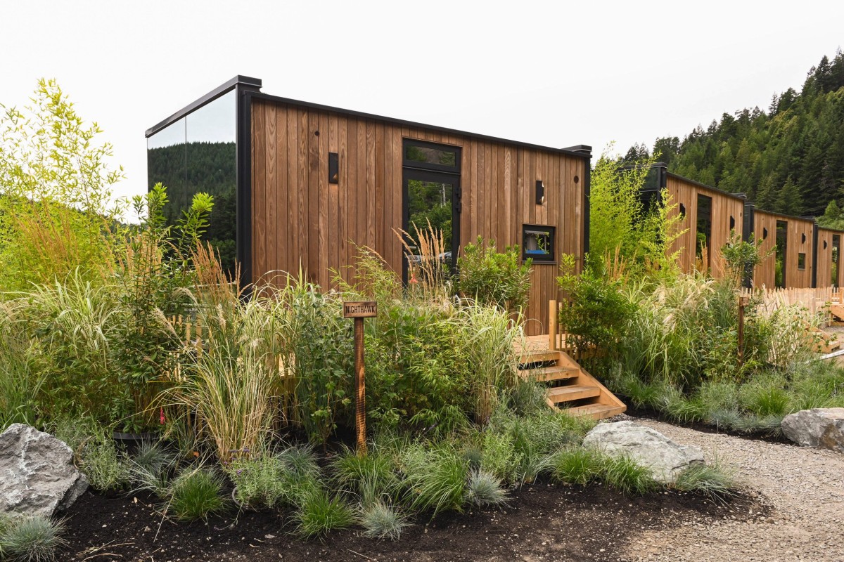 Las doce cabañas espejadas están distribuidas a lo largo de un terreno usado anteriormente como aparcamiento de caravanas.
